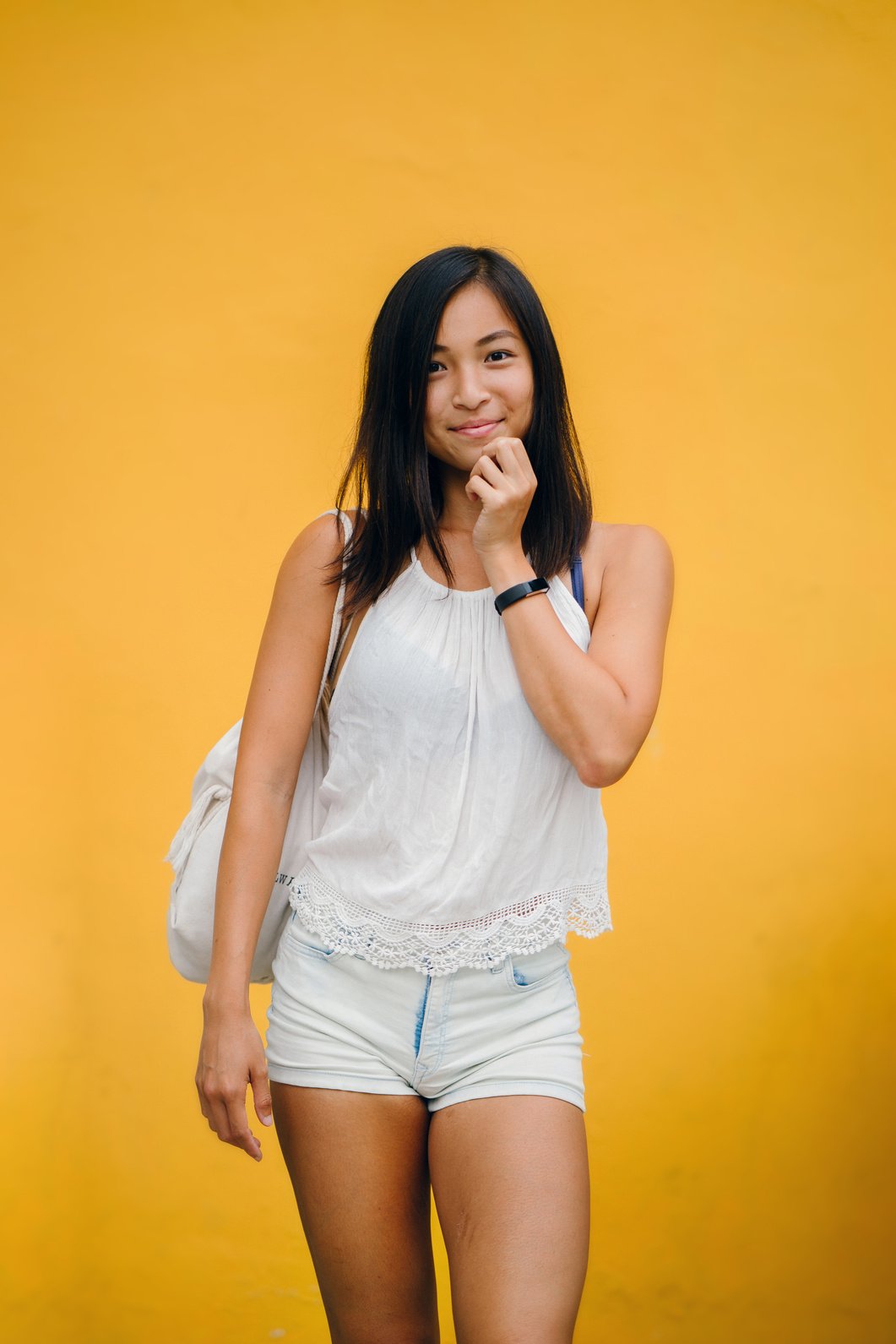 Woman in White Sleeveless Top on Yellow Background